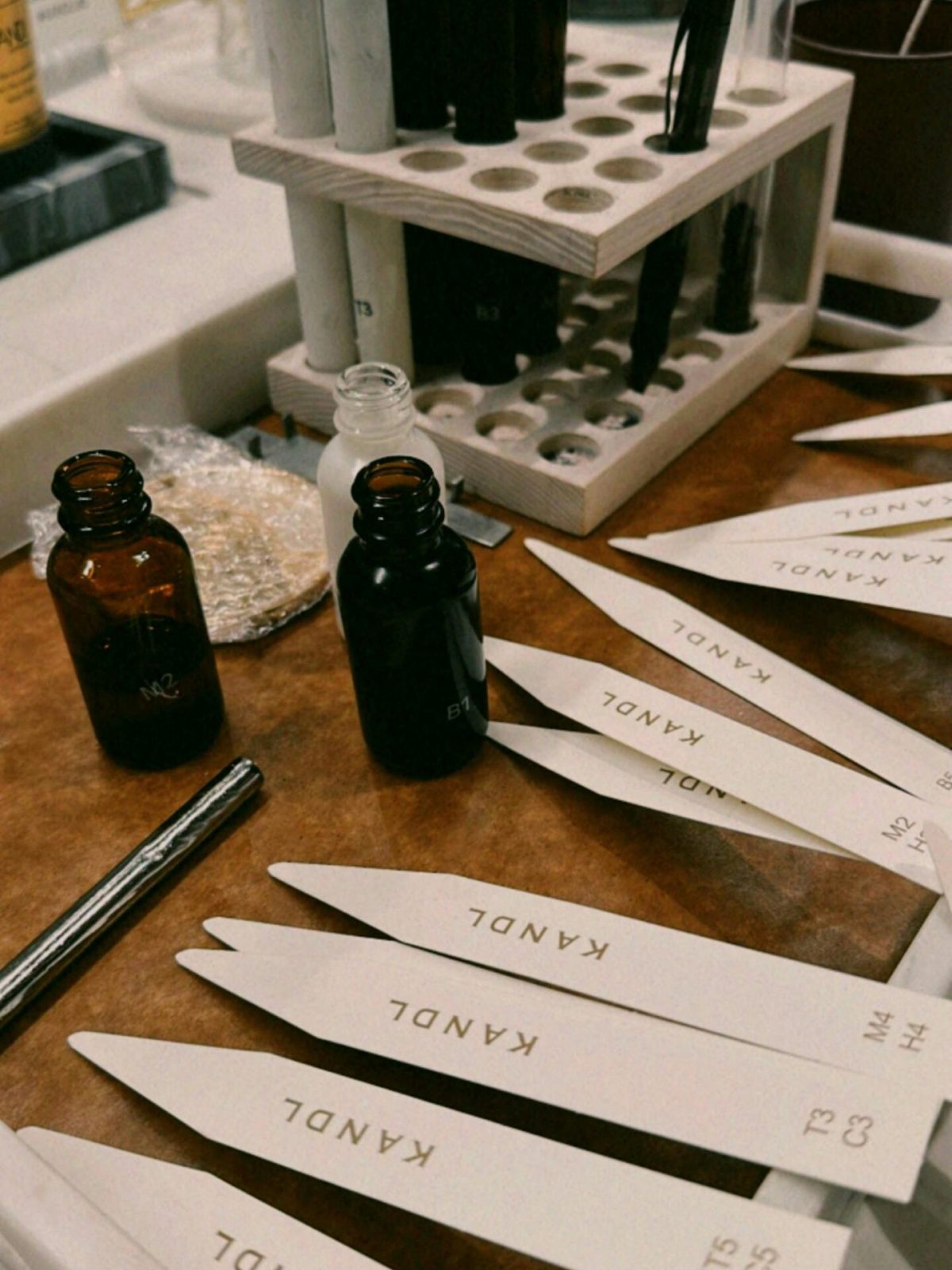 Aromatic candle making session showing scent bottles and fragrance strips on a table.