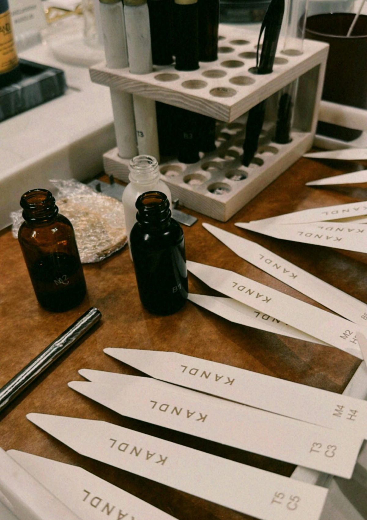 Aromatic candle making session showing scent bottles and fragrance strips on a table.